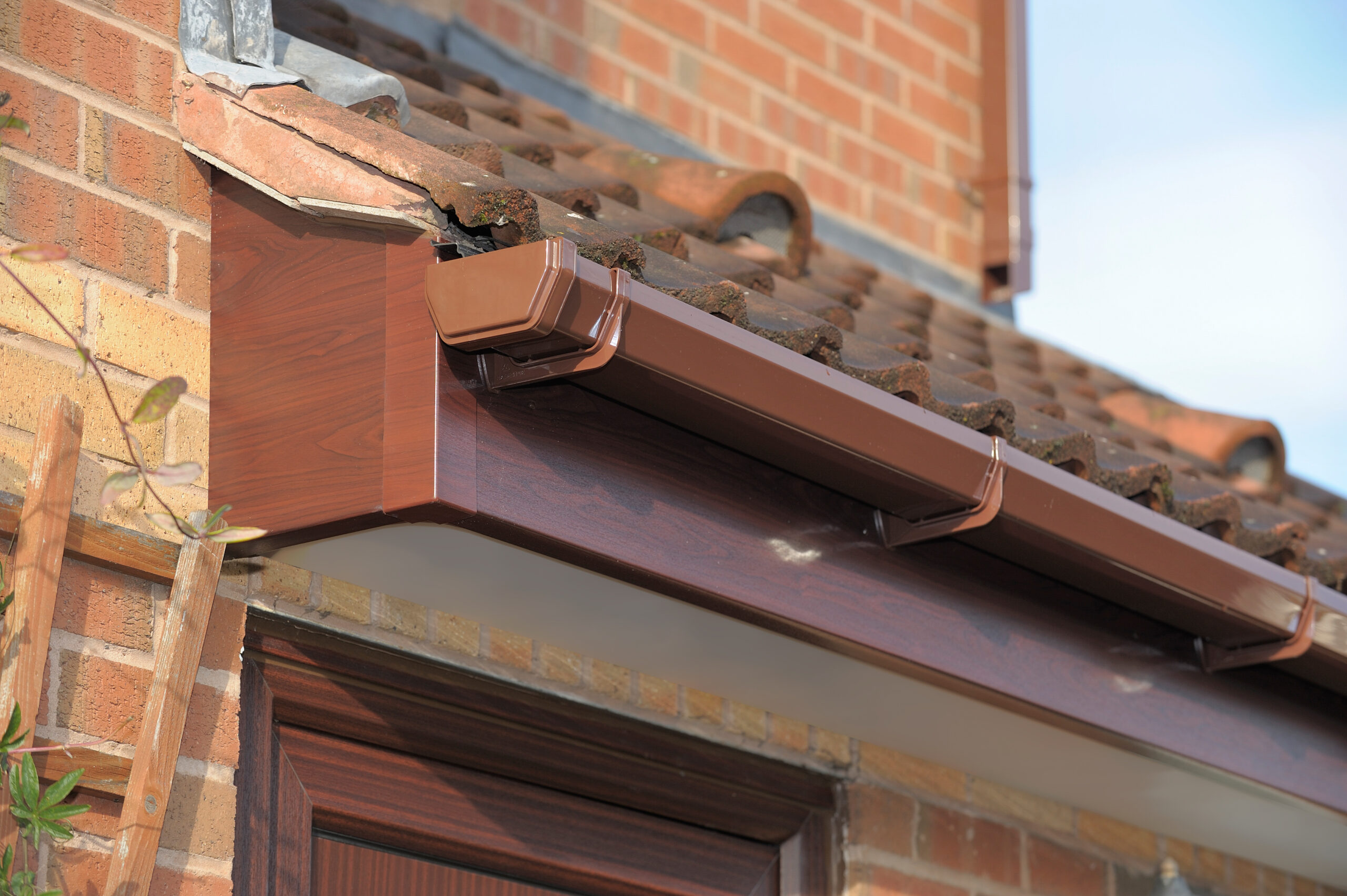 Global Roofline - fascia in Rosewood, soffit in white, rainwater system in Brown